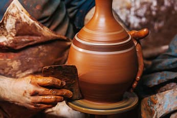 Hands of making clay pot on the pottery wheel ,select focus, clo